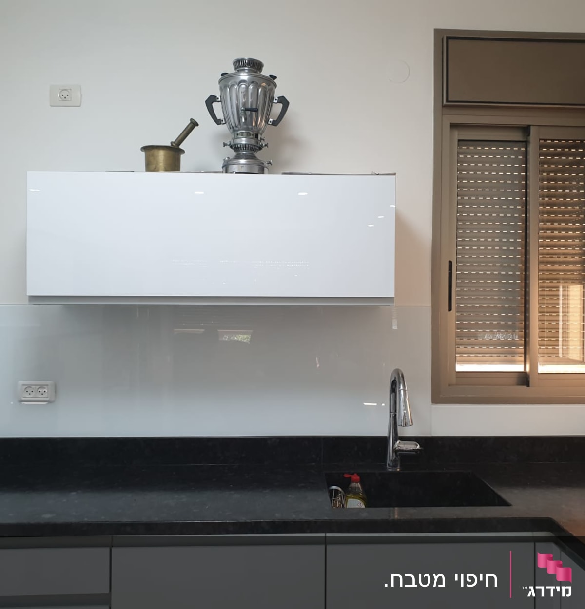 מטבח עם קיר זכוכית לבן מעל הכיור